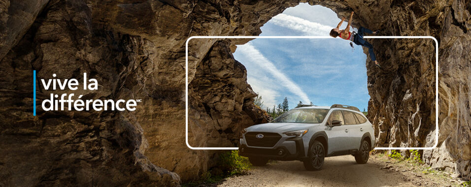 Une Subaru Outback 2023 sous un grimpeur en train d'escalader une grotte.